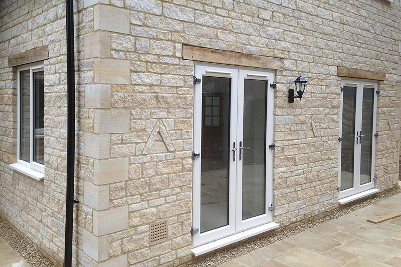 Timber-style French doors opening between interior and exterior spaces