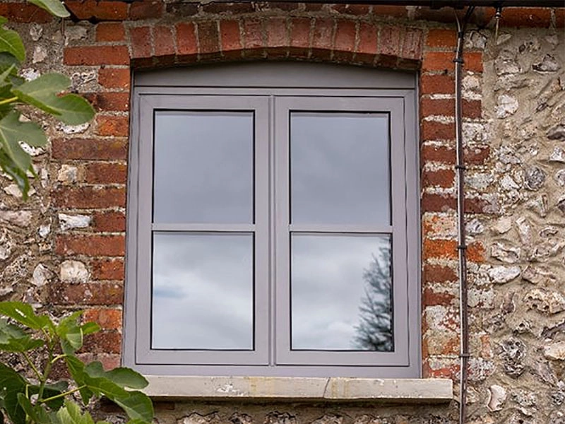 Black aluminium window installation on a traditional brick property
